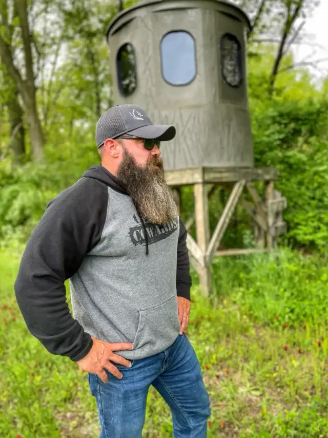 Sean Lundy looking out with hunting blind in background
