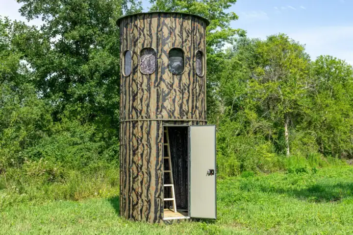 The Ultimate Blind set by a row of trees with the entry door open