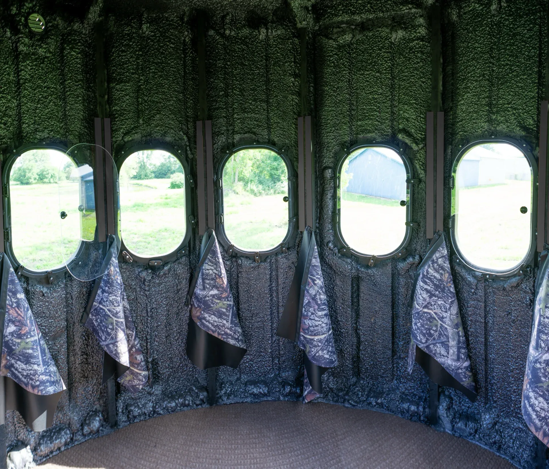 Inside The Ultimate Blind with 360 degree view outside with curtains hanging below windows