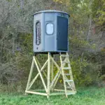 White Oak XT Blind in Fog Gray with combo gun and bow windows and side door set by edge of woods