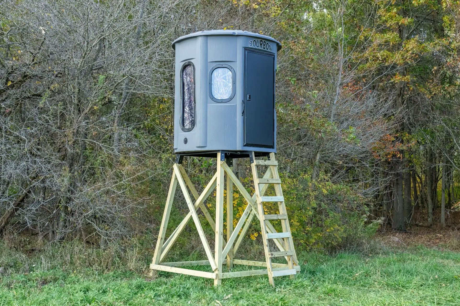 White Oak XT Blind in Fog Gray with combo gun and bow windows and side door set by edge of woods