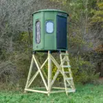 White Oak XT Blind in Forest Green with combo gun and bow windows and side door set by edge of woods