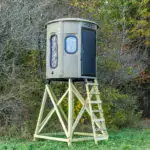 White Oak XT Blind in Tree Trunk color with combo gun and bow windows and side door set by edge of woods