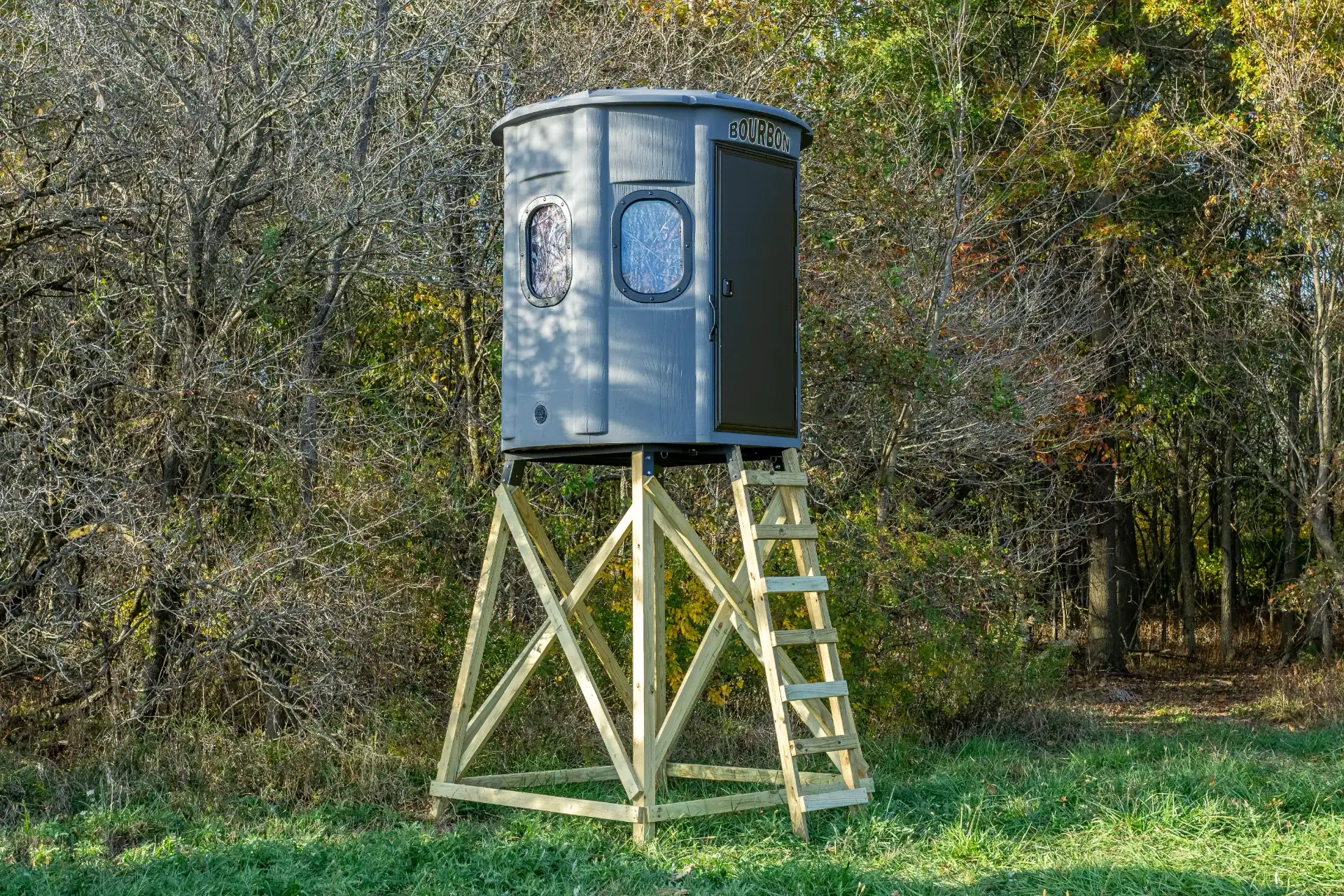 White Oak XT Blind in Fog Gray with gun windows and side door set by edge of woods