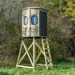 White Oak XT Blind in Tree Trunk color with gun windows and side door set by edge of woods